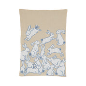 The in2green Baby Rabbits Blanket is a charming beige throw made from recycled cotton, featuring white rabbits outlined in blue, some playfully holding or playing with balls—perfect for gender-neutral decor.