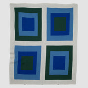 Explore the Bauhaus Throw Blanket by in2green, featuring a Bauhaus-inspired pattern of four squares layered with shades of blue and green on a light grey background. This design highlights an eco-friendly approach, seamlessly blending art with sustainability.