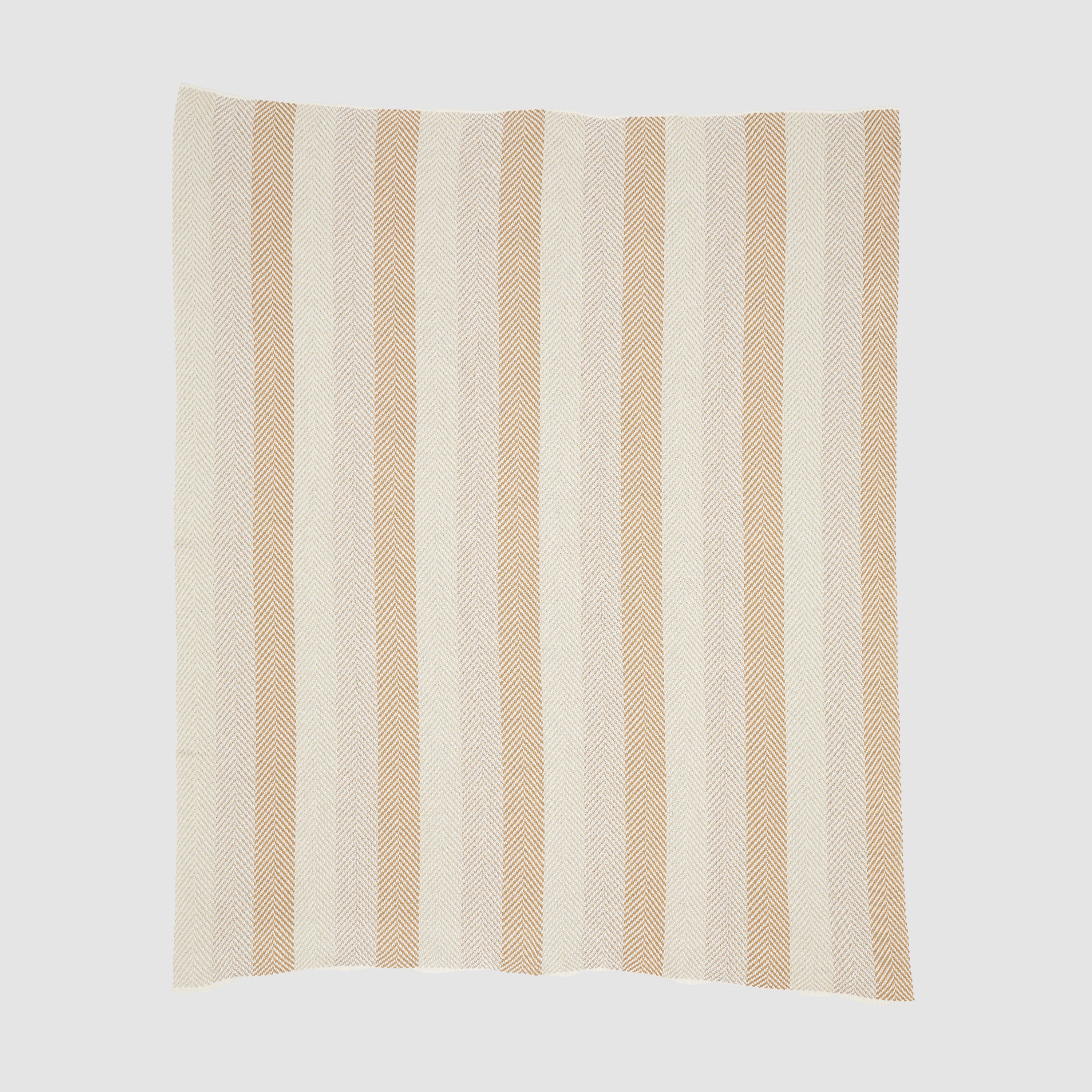 The Herringbone Hues Throw Blanket by In2Green is an eco-friendly creation made from recycled cotton, showcasing a square design with alternating vertical beige and tan stripes on a light background, proudly made in the USA.