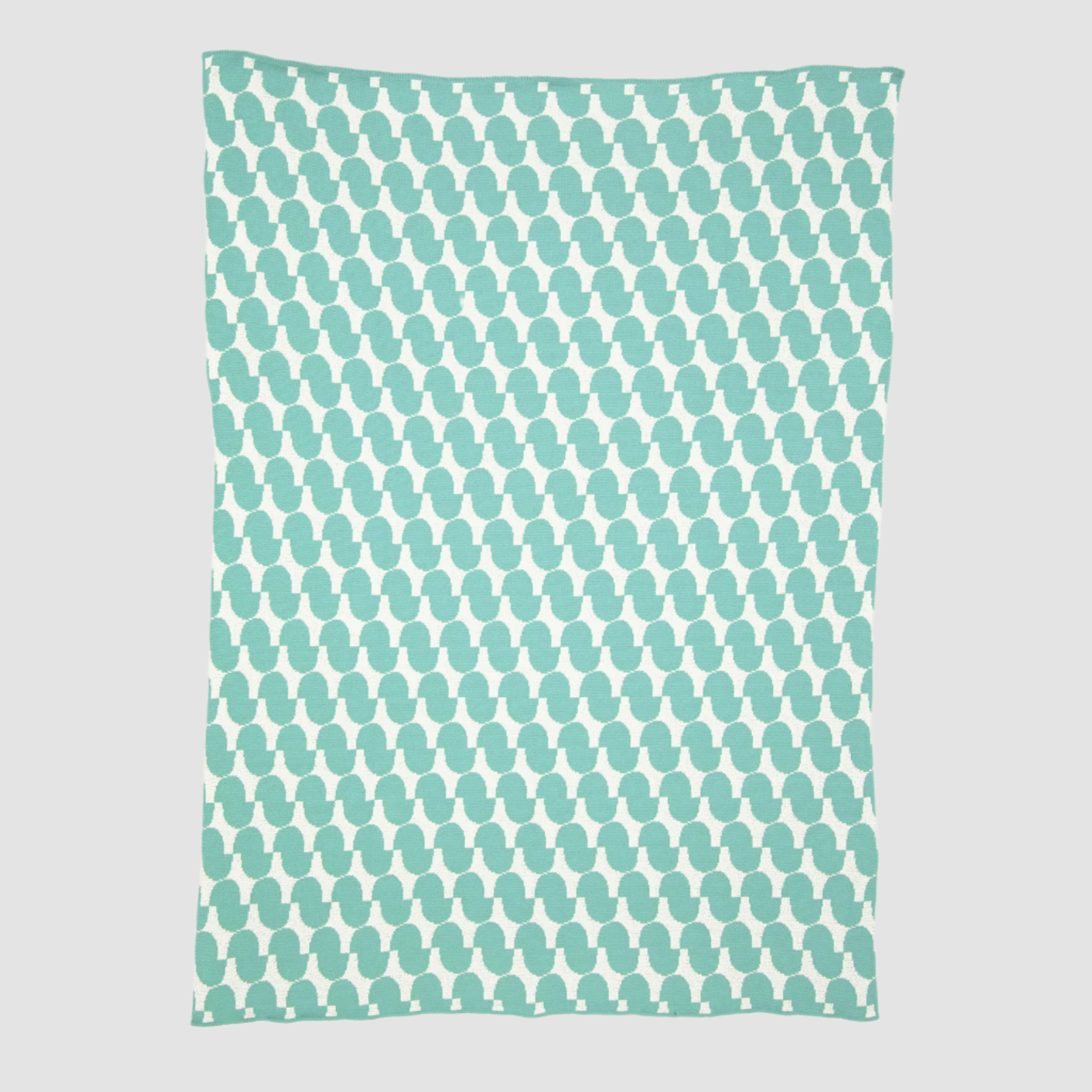 The Poly Juki Throw Blanket by Petra Kaksonen from in2green is a rectangular teal blanket made of recycled polyester yarn, showcasing a Scandinavian design with an enchanting pattern of white penguin silhouettes.