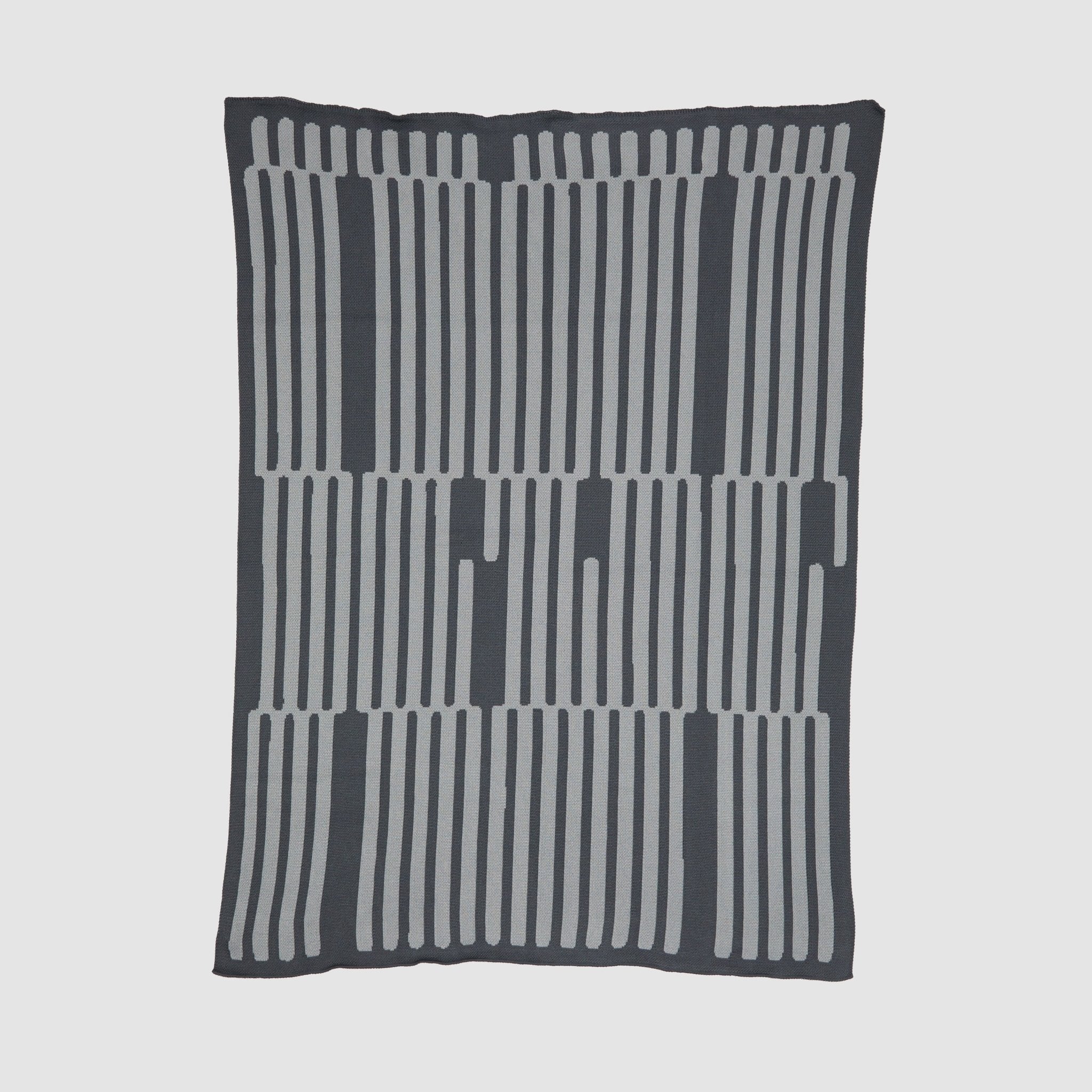 The Poly Retki Throw Blanket by Petra Kaksonen in charcoal and light grey