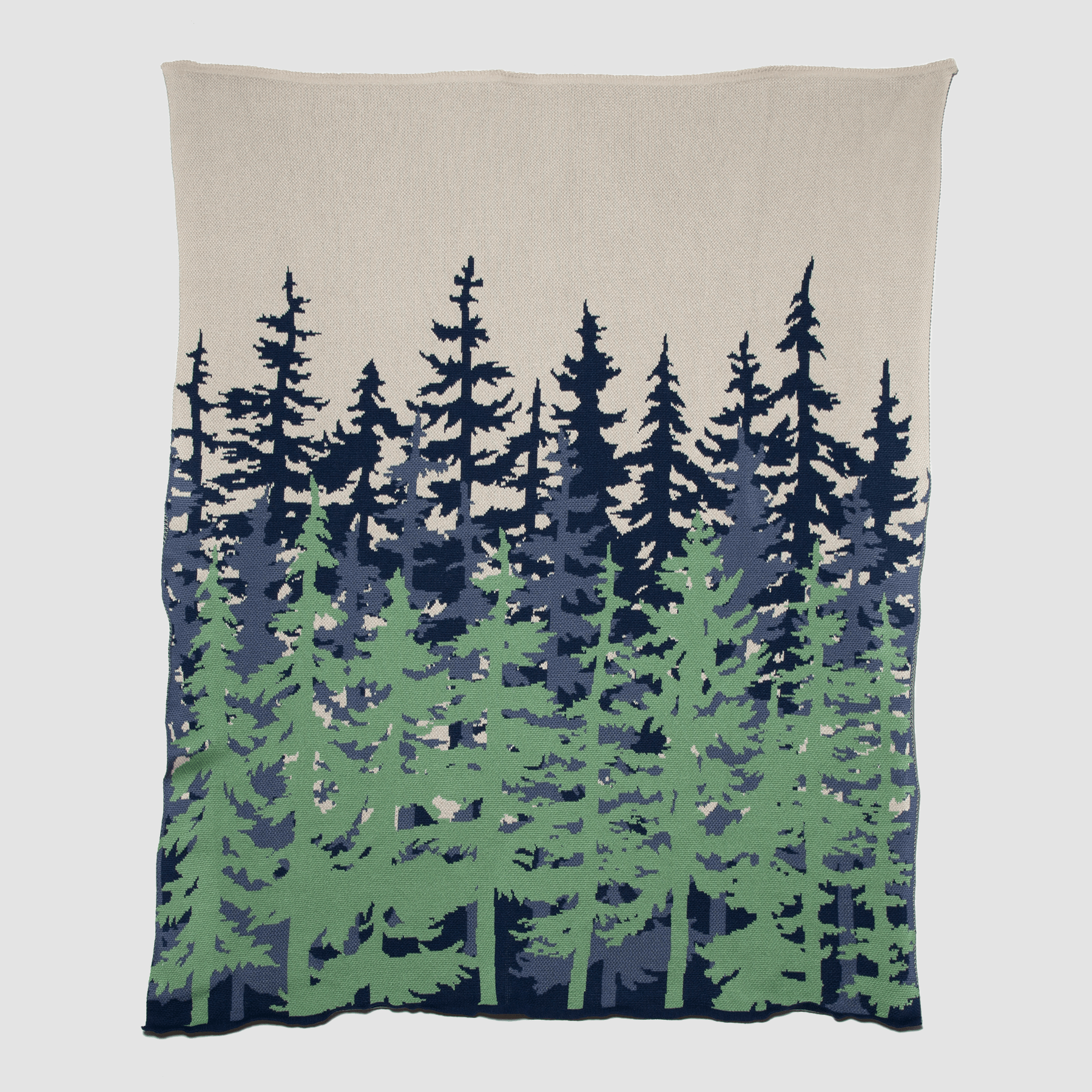 From the in2green outdoor collection, the Poly Tree Line Throw Blanket showcases a nature-inspired design with stylized green and dark blue trees on a beige background. Fade-resistant, it ensures lasting beauty for your cozy moments.